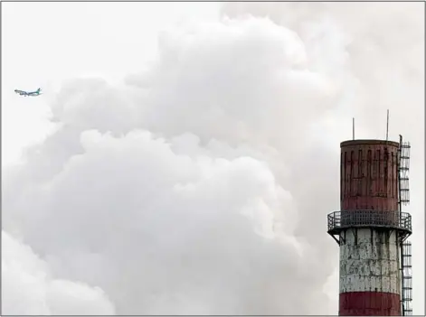  ?? (AP) ?? In this Feb 28, 2017 file photo, a passenger airplane flies behind steam and white smoke emitted from a coal-fired power plant in Beijing. On Nov 13, scientists
projected that global carbon pollution has risen in 2017 after three straight years when...