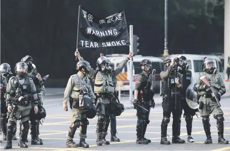  ?? Picture: AFP ?? FIRED-UP. Riot police hold up a black flag warning ahead of firing tear gas as people take part in a march from the Tsim Sha Tsui district to Hung Hom in Hong Kong yesterday. Tens of thousands of black-clad protesters flooded into the streets of Hong Kong yesterday, ending a brief election lull and demanding the government make concession­s after pro-democracy candidates won a landslide victory.