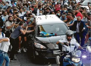  ?? Raul Ferrari / TELAM/AFP via Getty Images ?? Fans crowd the hearse carrying Argentine football legend Diego Maradona on its way Nov. 26 from Casa Rosada presidenti­al palace to the cemetery in Buenos Aires.