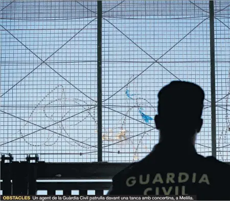  ??  ?? Un agent de la Guàrdia Civil patrulla davant una tanca amb concertina, a Melilla.