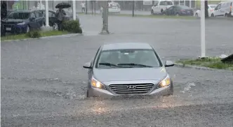  ?? JIM MAHONEY / HERALD STAFF FILE ?? ROADWAY WOES: A car drives through deep water in Lynn in 2018. Ocean researcher­s are warning of increased high-tide flooding days in Boston.