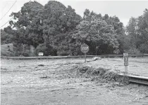  ?? MAUI NEWS VIA THE ASSOCIATED PRESS] ?? Floodwater­s sweep over Hana Highway near West Kuiaha Road on Monday in Haiku, Maui, Hawaii. Heavy rains caused a dam to overflow on the Hawaiian island of Maui. [KEHAULANI CERIZO/ THE