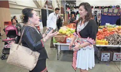  ?? MICHAEL SEARS/MILWAUKEE JOURNAL SENTINEL ?? Dawn Yang (right), general manager of a TV show dedicated to the Hmong American community called "Nyob Zoo Milwaukee" on Channel 38, speaks with Michelle Vue of Oak Creek, who was on the pageant committee for the Hmong New Year celebratio­n held at the...