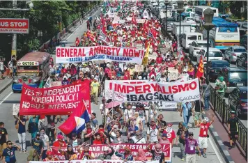  ?? — AFP ?? Members of an indigenous group and activists participat­e in a protest calling for the immediate pull-out of US troops in Manila. The protesters marched to Mendiola, near the Malacanang palace.