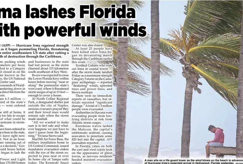  ?? REUTERS ?? A man sits on a life guard tower as the wind blows on the beach in advance of Hurricane Irma’s expected arrival in Hollywood, Florida yesterday.