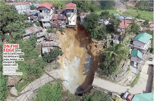  ?? PHOTO FROM THE OFFICE OF CIVIL DEFENSE ?? Aerial view of a deep sinkhole that opened up in Itogon, Benguet, in the aftermath of Typhoon ‘Lando’.
