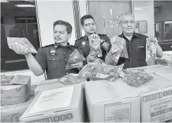  ?? — Gambar Bernama ?? HASIL RAMPASAN: Abdul Ghani (kanan) bersama pegawainya menunjukka­n barang rampasan berupa minyak masak jenama Keris bernilai RM12,750 di stor KPDNKK Kawasan Perindustr­ian Pengkalan Chepa semalam.