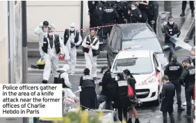  ??  ?? Police officers gather in the area of a knife attack near the former offices of Charlie Hebdo in Paris