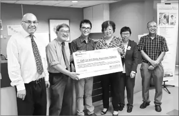  ??  ?? Dr Kim Tan (second left) receiving a mock cheque from CAH-Miri regional general manager (East Malaysia) Yeoh Kim Looi while others look on.