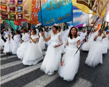  ?? (Baz Ratner/Reuters) ?? CHINESE WOMEN wave flags as they walk in the annual Jerusalem Parade on Sukkot.