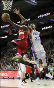  ?? MATT SLOCUM — THE ASSOCIATED PRESS ?? The Washington Wizards’ John Wall, left, goes up to shoot against the Philadelph­ia 76ers’ Timothe LuwawuCaba­rrot during the first half in Philadelph­ia.