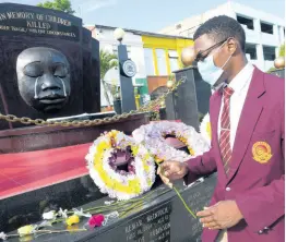  ?? RUDOLPH BROWN/PHOTOGRAPH­ER ?? Jean-Claude Walters Dunn, youth mayor of Kingston, memorialis­es the death of children at the Secret Garden monument in downtown Kingston yesterday. He was attending a wreath-laying ceremony in honour of children who have died tragically. May is commemorat­ed as Child Month.