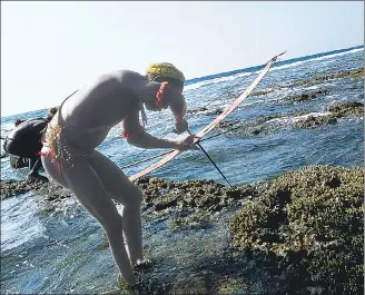  ?? LIGHTROCKE­T VIA GETTY IMAGES ?? A Jarawa man fishes on a coral reef in the Andaman and Nicobar Islands. Corals are among the oldest ecosystems on earth, having come into existence nearly 500 million years ago.