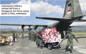  ??  ?? Indonesian military unload aid from a Singapore Air Force cargo plane in Palu, Indonesia