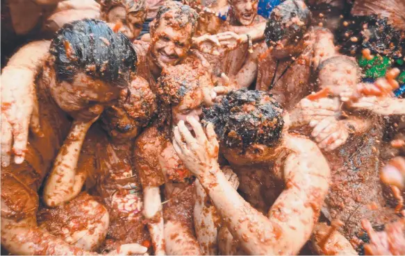  ?? Picture: AFP ?? Revellers are pelted with tomatoes during the world’s biggest food fight, the Tomatina festival in Bunol, yesterday.