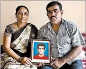  ??  ?? Menavati and Dadaro Bilhore hold a photo of Prakash, who died when the motorbike he was on hit a pothole in 2015.