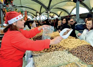  ??  ?? Commercian­ti con giacca rossa e cappello di Babbo Natale per sottolinea­re l’atmosfera natalizia e invogliare i clienti