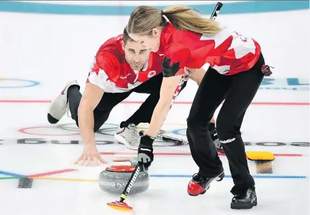  ?? NATHAN DENETTE/THE CANADIAN PRESS ?? Kaitlyn Lawes and John Morris get down to business in the mixed doubles gold-medal game against Switzerlan­d at the Olympic Winter Games in Gangneung, South Korea, on Tuesday. The Canadian duo dominated, winning 10-3.