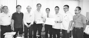  ??  ?? Chok (fourth right), Foo (third right) and Tan Kai (fourth left) show the plans for flash flood solutions and on-going drainage constructi­on for certain areas in the city while Sih (second left) and others look on.