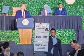  ?? STEVE HELBER/ASSOCIATED PRESS ?? Virginia Del. Ibraheem Samirah, D-Fairfax, yells as he interrupts President Donald Trump’s speech Tuesday in Jamestown, Va., during a commemorat­ive meeting of the Virginia General Assembly.