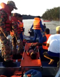  ??  ?? SAR team members transport the body of Awang Syukri on board their rescue boat.