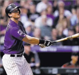  ?? David Zalubowski ?? The Associated Press Rockies second baseman DJ Lemahieu follows the flight of his two-run, walk-off home run to beat the Diamondbac­ks on Wednesday in Denver.