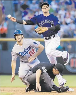  ?? Jack Dempsey
Associated Press ?? CLAYTON KERSHAW stays at second base as Rockies shortstop Troy Tulowitzki jumps over umpire Chris Guccione to throw to first to get out the Dodgers’ Joc Pederson.