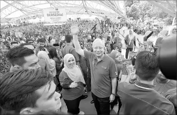  ??  ?? Najib, accompanie­d by Mas Ermieyati, waves after launching the Sahabat Puteri BN: AZALEA 2018 programme. — Bernama photo