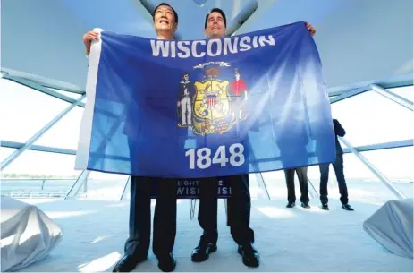  ??  ?? Foxconn Chairman Terry Gou ( left) and Wisconsin Gov. Scott Walker hold the Wisconsin flag to celebrate their $ 10 billion investment to build a display panel plant in Wisconsin, at the Milwaukee Art Museum in Milwaukee on July 27.
| MIKE DE SISTI/...