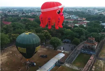  ??  ?? This aerial photograph shows hot air balloons flying over the former capital’s stone citadel during a hot air balloon festival in the central Vietnamese city of Hue. — AFP photo