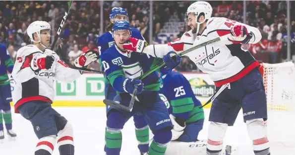  ?? DARRYL DYCK/THE CANADIAN PRESS ?? Canucks winger Tanner Pearson takes a shot in the face from Capitals tough guy Tom Wilson during Friday night’s wild contest at Rogers Arena.