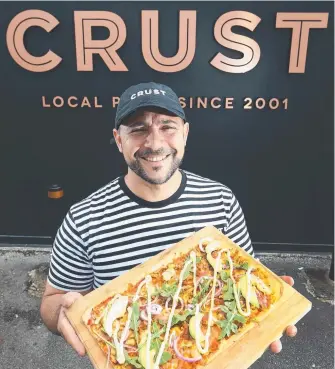  ??  ?? Crust Pizza Nerang store owner Sam El-Debel in front of the new-look shop.