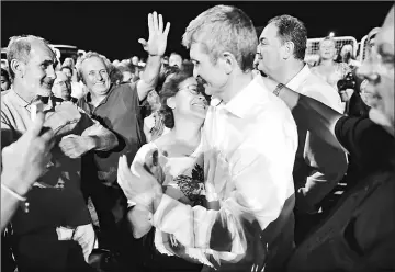  ??  ?? Kemal Güngör (centre right), a board member of the foundation that publishes the embattled opposition newspaper Cumhuriyet, embraces his wife after being freed from Silivri prison. — AFP photo