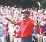  ?? Tim Bradbury / Getty Images ?? Tiger Woods celebrates making a par on the 18th green to win the Tour Championsh­ip at East Lake Golf Club on Sunday in Atlanta.