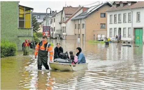  ?? FOTO: BECKERBRED­EL ?? Das Hochwasser führte dazu, dass die Helfer Häuser evakuieren mussten. Hier holen sie Menschen im Boot aus der überflutet­en Elässer Straße.