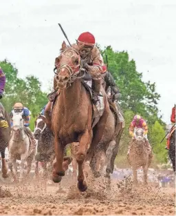  ?? MICHAEL CLEVENGER AND O'NEIL ARNOLD/LOUISVILLE COURIER-JOURNAL ?? Rich Strike, with jockey Sonny Leon aboard, runs to victory in the Kentucky Derby on May 7.