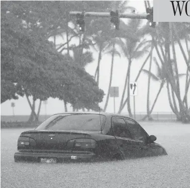  ?? MARIO TAMA/GETTY IMAGES ?? A car sits partially submerged in floodwater­s from Hurricane Lane in Hilo, Hawaii, on Thursday.