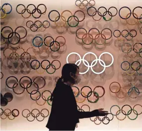  ?? EUGENE HOSHIKO/AP ?? A worker is seen at the Japan Olympic Museum, where a lantern containing the Olympic Flame shown prior to public display, on Aug. 31 in Tokyo. The postponed Tokyo Olympics are to open in just under nine months, and there are still far more questions than answers.