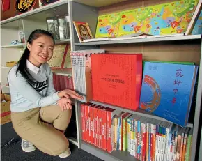  ??  ?? Volunteer Mandarin tutor Sunny Shan with resources gifted by the Confucius Institute to Aoraki Polytechni­c in Timaru. Overseas government­s and organisati­ons have stepped into the language gap here, says Simon Draper.