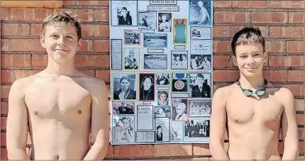  ?? ?? 13-year-old Janco Grobbelaar (left), and 14-year-old Dewet Gous broke their personal best lap times and in doing so also set new Northern Cape Aquatics Sports Associatio­n records for their age groups. They are seen standing next to a poster outlining the swimming history of Kimberley swimming hero Karen Muir.