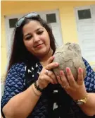  ??  ?? ‘Dinosaur Princess’ Aaliya Sultana Babi holding a fossilized dinosaur egg at her palace in Balasinor.