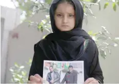  ?? — Reuters ?? Farah, daughter of Walid al Abidi, who was killed by IS militants at Kirkuk road, holds his picture, in Kerbala, Iraq.