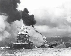  ?? ?? The capsized USS Oklahoma lies next to a slightly damaged USS Maryland on Dec. 7, 1941.