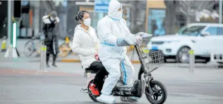  ?? Foto: Efe ?? Un trabajador sanitario voluntario pasea en moto por las calles de Pekín, China.