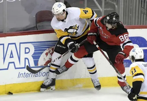  ?? Associated Press ?? Devils center Jack Hughes fights for the puck with Penguins defenseman Cody Ceci in the second period.