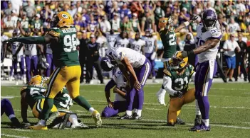  ?? MATT LUDTKE/AP ?? Vikings kicker Daniel Carlson, center, hangs his head after missing a field goal in overtime during Minnesota’s tie with the Packers on Sunday. The miss and two others coast Carlson his job. He was released and the Vikings signed former Cowboys kicker Dan Bailey.