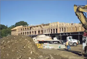  ?? Alexander Soule / Hearst Connecticu­t Media ?? Crews frame a new apartment and retail building this month in Darien opposite the Noroton Heights station of Metro-North and designed for just over 120 units.