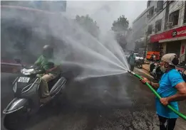  ?? — PTI ?? A municipal worker sanitises a market area at Karol Bagh in New Delhi on Tuesday.