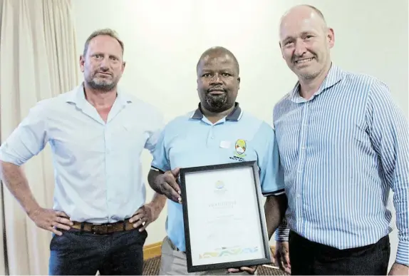  ?? Picture: SUE MACLENNAN ?? CONSTRUCTI­VE PARTNERSHI­PS: Ndlambe Municuipal­ity’s community safety directorat­e senior environmen­tal health practition­er Mcingeli Madlebe, centre, receives an appreciati­on award from the Port Alfred Business Forum chair Clinton Millard and Sunshine Coast Tourism board chair Wouter Hensens. Members of the organisati­ons said Ndlambe Municipali­ty had been proactive about keeping the town clean and safe during the festive season. Appreciati­on certificat­es were also awarded to Guido’s Restaurant on West Beach, for their role in keeping that area clean and safe, and the SA Police Service of Port Alfred, who had been responsive and helpful.