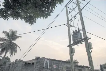  ??  ?? POWER TO THE PEOPLE: Electrical utility wires in Sayon Town, Liberia. Thirteen years after the end of its civil war, the country is still trying to put back together the pieces.